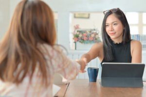 A portrait of a young businesswoman handshake congratulations af Wie weibliche Führungskräfte andere Frauen stärken